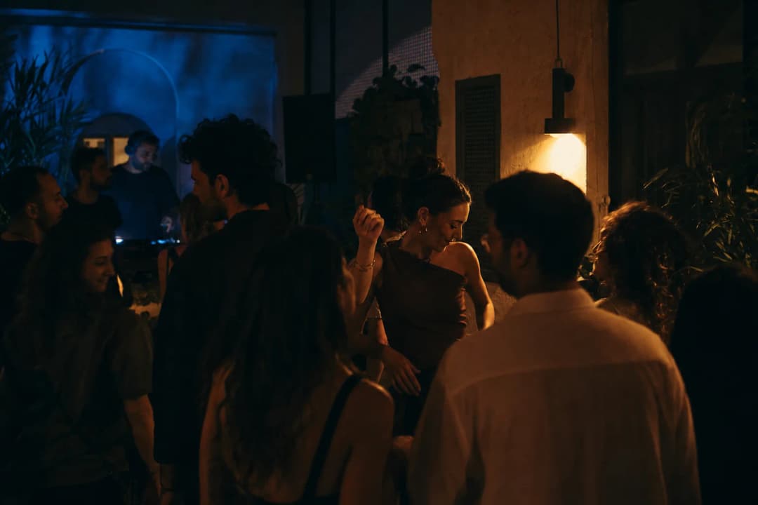 Crowd during an amber-lit DJ set